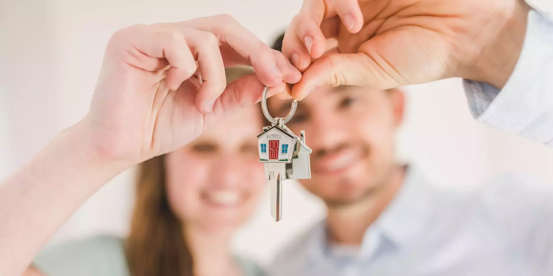 mężczyzna i kobieta trzymaja klucze do swojego domu